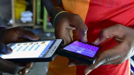 Ce Ivoiriens naviguent sur internet avec leurs smartphones à Abidjan, le 20 septembre 2016. ( ISSOUF SANOGO/AFP)