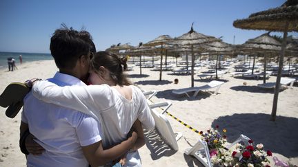 Des touristes viennent se recueillir&nbsp;sur la plage o&ugrave; 38 personnes ont &eacute;t&eacute; tu&eacute;es &agrave; Sousse (Tunisie), vendredi 26 juin 2015.&nbsp; (KENZO TRIBOUILLARD / AFP)