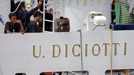 Des migrants attendent de pouvoir débarquer du Diciotti au port de Catane, en&nbsp;Sicile. (GIOVANNI ISOLINO / AFP)