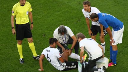 Klaus Eder (de dos), au chevet de&nbsp;Sami Khedira, le 2 juillet, lors du quart de finale entre l'Allemagne et l'Italie.&nbsp; (CHRISTIAN CHARISIUS / DPA / AFP)