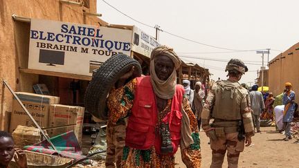 De dos, soldat français de l'opération Barkhane sur le marché de Menaka,&nbsp;au nord-est du Mali. Dans cette ville, non loin de la frontière avec le Niger, des ONG françaises remettent en fonctionnement l'eau, l'electricité. Photo prise le 27 juin 2019.&nbsp; (MARIE WOLFROM / AFP)