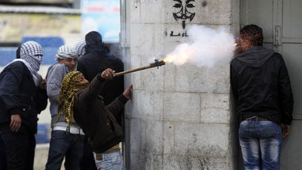 Un manifestant palestinien utilise un lance-roquette artisanal pour tirer des p&eacute;tards lors d'affrontements avec des soldats isra&eacute;liens &agrave; H&eacute;bron (Palestine), le 24 f&eacute;vrier 2013. (AMMAR AWAD / REUTERS)