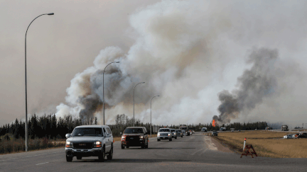 &nbsp; (Un convoi d’habitants de Fort McMurray fuit la ville face à l’incendie hors de contrôle © REUTERS/Mark Blinch)