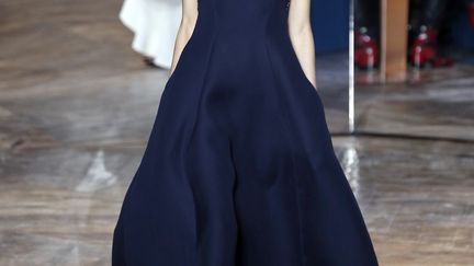 Le défilé Dior orchestré par l'équipe du studio maison a proposé des silhouettes féminines et décontractées. Les décolletés dénudent les épaules, souvent de façon asymétrique dans cette collection qui joue les variations autour du tailleur "Bar", icône du style "New Look" de Christian Dior. Dans cette collection, aisément portable, les femmes Dior s'habillent "avec liberté et sans apprêt" et "définissent un nouveau réalisme de la couture", indique un communiqué. Avant la nomination d'un successeur à Raf Simons, la collection a été orchestrée par les stylistes suisses Serge Ruffieux et Lucie Meier. "L'objectif, c'est que ces robes, ces tailleurs, ces vestes soient portés!  Le PDG de Dior, Sidney Toledano a indiqué, quant au choix d'un nouveau D.A, "on donne du temps au temps", a-t-il dit. Le candidat idéal sera "celui qui comprendra la marque, qui saura se souvenir des bases de Dior, et comprendre l'air du temps, c'est ce que Monsieur Dior avait senti d'une manière géniale en son temps, c'est ce que les autres créateurs ont apporté à cette maison". 
 (FRANCOIS GUILLOT / AFP)