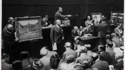 Vente aux enchères de la collection Jacques Cannone, Hôtel Drouot, Paris, 5 juin 1942. Sous le marteau du commissaire-priseur Maître Alphonse Bellier, assistés par les experts André Schoeller et Martin Fabiani (assis derrière la petite table à droite). (MUSÉE CARNAVALET / ROGER-VIOLLET)