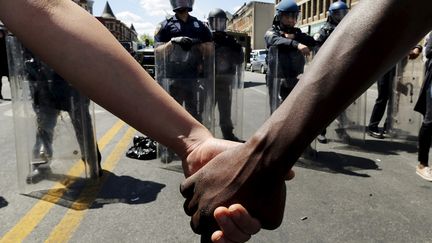 Les manifestations pacifiques de protestation se poursuivent &agrave; Baltimore pour protester contre la mort de Freddy Gray : ici, face &agrave; la police, des manifestants se tiennent la main, le 28 avril 2015. (© JIM BOURG / REUTERS / X90054)