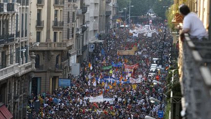 Un homme regarde depuis son balcon la manifestation qui a eu lieu &agrave; Barcelone jeudi 19 juillet. (ALBERT GEA / REUTERS)