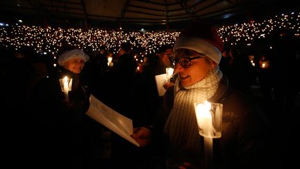 Des personnes chantent des chants de Noël, dans un stade de Berlin (Allemagne), samedi 23 décembre 2017.&nbsp; (HANNIBAL HANSCHKE / REUTERS)