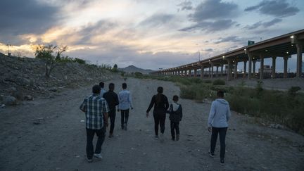 Des migrants tentent de franchir la frontière entre les Etats-Unis et le Mexique, le 29 avril 2019. (PAUL RATJE / AFP)