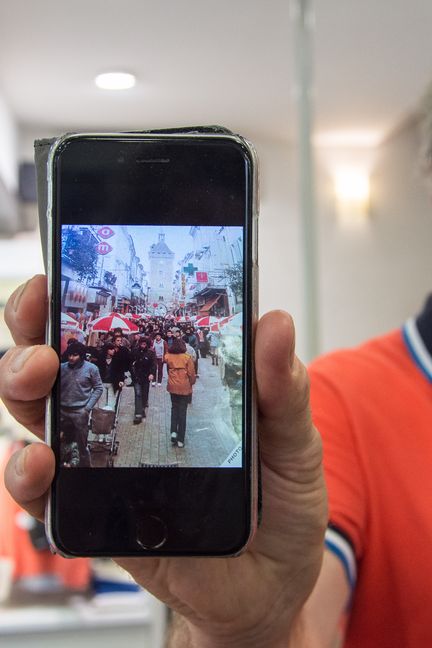 Gérard Majos, patron de la boutique du même nom, montre une photo&nbsp;de l'inauguration de la piétonnisation de la rue de Paris en 1981. "On pouvait à peine marcher" se souvient-il.&nbsp;&nbsp; (JULIETTE CAMPION / FRANCEINFO)