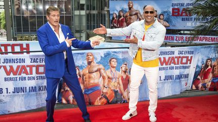 C'est Dwayne Johnson (à droite) qui reprend le flambeau pour le rôle de leader des sauveteurs de la plage de Malibu, après David Hasselhoff (à gauche).&nbsp; (KLAUS WERNER/GEISLER-FOTOPRESS / GEISLER-FOTOPRESS)