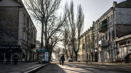 Une personne dans les rues de Kherson, en Ukraine, le 11 avril 2023. (JOSE COLON / ANADOLU AGENCY / AFP)