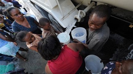 Des victimes du séisme prennent de l'eau à un camion-citerne le 18 janvier 2010 à Port-au-Prince (AFP PHOTO - Jewel SAMAD)