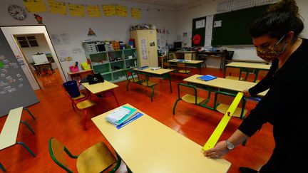 Une enseignante mesure la distance entre les tables à l'école élémentaire Jean-Jaurès de Cenon près de Bordeaux, le 11 mai 2020 (photo d'illustration) (MEHDI FEDOUACH / AFP)