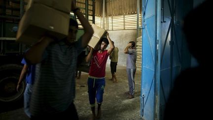 Des travailleurs palestiniens transportent des cartons d'aide alimentaire, le 22 septembre 2015 à Gaza. (MOHAMMED SALEM / REUTERS / X01571)