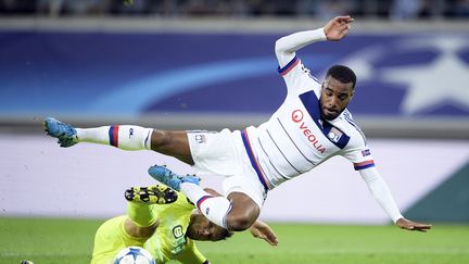 L'attaquant lyonnais Alexandre Lacazette tacl&eacute; par un d&eacute;fenseur de La Gantoise, lors d'un match de Ligue des Champions, le 16 septembre 2015 &agrave; Gand (Belgique). (YORICK JANSENS / AFP)