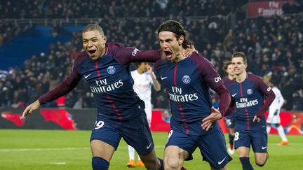 Kylian Mbappé félicite Edinson Cavani après que ce dernier ait inscrit le troisième but du PSG contre l'OM, le 25 février 2018 au Parc des Princes. (PIERRE CHARLIER / AFP)