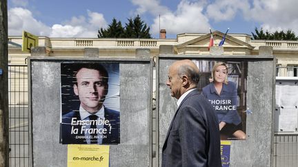 Le maire de Bordeaux, Alain Juppé, devant les affiches des deux candidats au second tour de l'élection présidentielle, le 7 mai 2017 à Bordeaux. (MAXPPP)