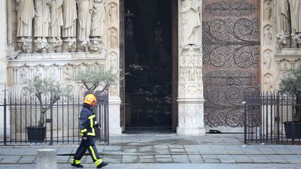 Un pompier marche devant Notre-Dame de Paris, le 16 avril 2019. (POOL NEW / REUTERS)