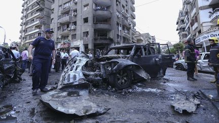 Des membres des services de s&eacute;curit&eacute; &eacute;gyptiens inspectent la voiture du procureur g&eacute;n&eacute;ral &eacute;gyptien, tu&eacute; dans une attaque &agrave; la bombe au Caire, le 29 juin 2014. (MOHSEN NABIL / ANADOLU AGENCY / AFP)