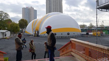 Des bénévoles d'Emmaüs Solidarité devant le nouveau centre d'accueil pour migrants de Paris, boulevard Ney, le 8 novembre.&nbsp; (CHRISTOPHE ARCHAMBAULT / POOL)