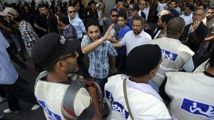 Des islamistes tunisiens se frayent un passage parmi les policiers apr&egrave;s la pri&egrave;re du vendredi, le 15 juin 2012, &agrave; Tunis.&nbsp; (FETHI BELAID / AFP)