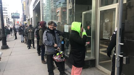 File d'attente devant une boutique de la Société québécoise du cannabis, à Montréal (Canada) le 18 mars 2020, pendant le 1er confinement dû au Covid-19 (JACQUES LEMIEUX / AFP)