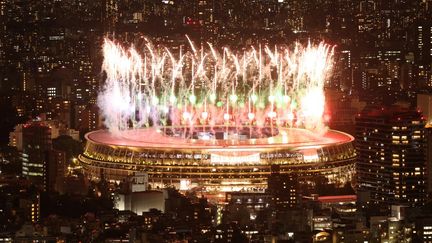 Des feux d'artifice illuminent le ciel au-dessus du stade olympique lors de la cérémonie d'ouverture des Jeux paralympiques de Tokyo 2020, le 24 août 2021. (BEHROUZ MEHRI / AFP)