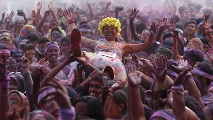 Une jeune femme est port&eacute;e par la foule lors de la Color Run &agrave; Kuala Lumpur (Malaysie), le 17 ao&ucirc;t 2014. (OLIVIA HARRIS / REUTERS)