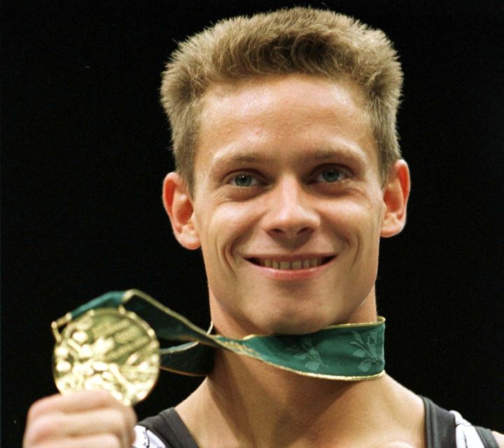 L'Allemand&nbsp;Andreas Wecker pose avec sa m&eacute;daille d'or en barre fixe, aux JO d'Atlanta (Etats-Unis), le 29 juillet 1996. (KIMIMASA MAYAMA / REUTERS)