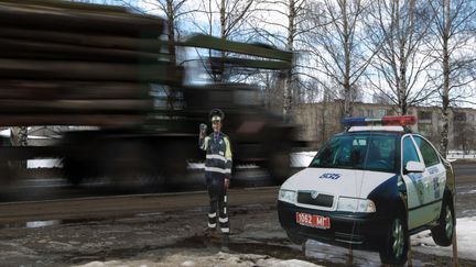 Un camion passe devant un policier en carton &agrave; Krugloe (Bi&eacute;lorussie), le 13 mars 2012. (VASILY FEDOSENKO / REUTERS)