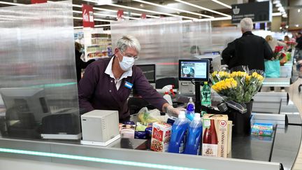 Une caissière équipée d'un masque et de gants pour se protéger durant l'épidémie de coronavirus, le 19 mars 2020, dans un hypermarché de Colmar (Haut-Rhin). (MAXPPP)