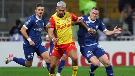 Le Lensois Facundo Medina à la lutte avec le Marseillais Jordan Veretout, le 12 novembre 2023 en Ligue 1. (FRANCOIS LO PRESTI / AFP)