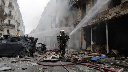 Un pompier&nbsp;devant les lieux de l'explosion qui a ravagé la rue de Trévise, dans le 9e arrondissement de Paris, le 12 janvier 2018. (THOMAS SAMSON / AFP)