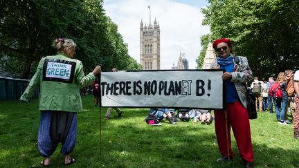 "Pensez vert", "Il n'y a pas de planète B", pouvait-on lire sur la veste verte et la banderole de manifestants mobilisés par l'urgence climatique le 26 juin 2019 à Londres, du côté de Westminster (WIKTOR SZYMANOWICZ / NURPHOTO / AFP)