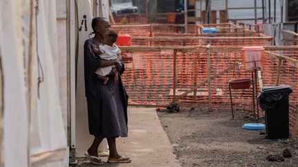 Une femme sort d'une tente après avoir été prise en charge pour le mpox, dans le camp de déplacés de Munigi, en RDC. (MOISE KASEREKA / EPA)