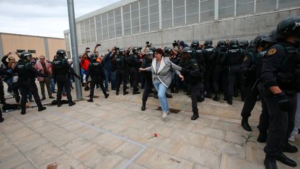 Une partisane du référendum d'indépendance catalan arrêtée par les forces de l'ordre espagnoles à Barcelone, le 1er octobre 2017. (ALBERT GEA / REUTERS)