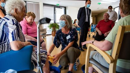 Une salariée d'un Ehpad de Chauvigny (Vienne) rafraîchit les pieds de résidents, le 16 juin 2022, lors d'un épisode de canicule précoc. (MAXPPP)