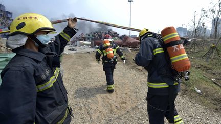 Des pompiers sur le site des explosions de Tianjin (Chine), le 14 ao&ucirc;t 2015. (YUE YUEWEI / XINHUA / AFP)