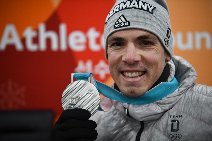 Le biathlète allemand Simon Schempp pose avec sa médaille d'argent aux Jeux olympiques de Pyeongchang (Corée du Sud), le 19 février 2018. (FRANCK FIFE / AFP)