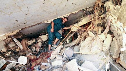 A man searches for survivors in the rubble of homes in Derna on September 14 in Libya, after deadly floods which hit the east of the country.  (ABDULLAH DOMA / AFP)