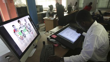 Un illustrateur de l'entreprise Kuluya Games de Lagos, au Nigeria, travaille sur une palette graphique.&nbsp; (AKINTUNDE AKINLEYE / X02000)