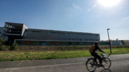 Un cycliste passe devant le bâtiment de l'Institut universitaire de cancérologie de Toulouse (Oncopole) à Toulouse, le 12 octobre 2022. Photo d'illustration. (CHARLY TRIBALLEAU / AFP)