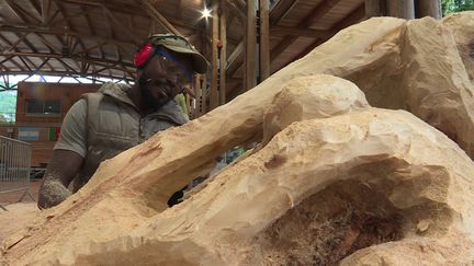 Le sculpteur camerounais&nbsp;Armand Kebfoube en pleine création. (CAPTURE D'ÉCRAN FRANCE 3 / D. LOUVET)