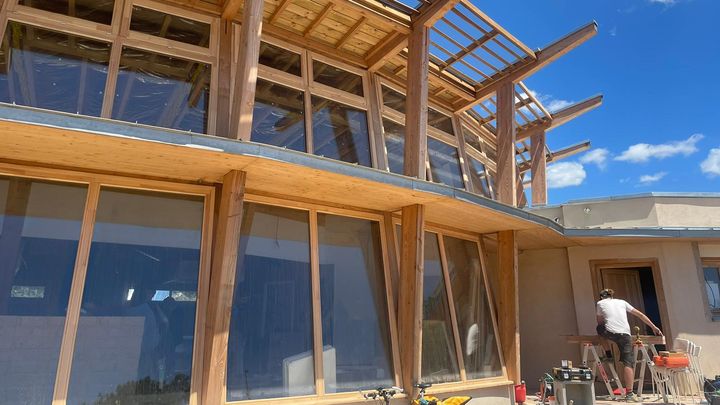 Dans ce restaurant, tout a été pensé pour économiser l'énergie : la charpente en bois, les murs en béton de chanvre et au fond, à l'extérieur, deux immenses miroirs paraboliques qui réfléchissent et concentrent les rayons du soleil.  (MATHILDE VINCENEUX / RADIOFRANCE)