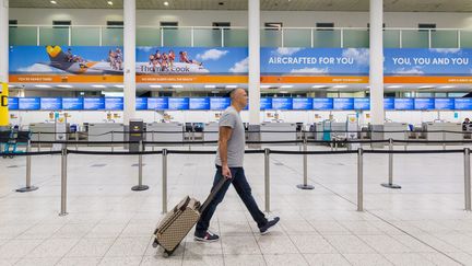 Un voyageur devant un guichet d'enregistrement Thomas Cook dans un aéroport en Angleterre le 23 septembre 2019.&nbsp; (VICKIE FLORES / EPA)