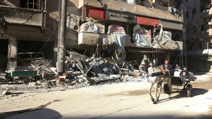 Des habitants passent devant l'hôpital bombardé Al-Hakeem, dans la ville assiégée d'Alep, en Syrie, le 19 novembre 2016. (ABDALRHMAN ISMAIL / REUTERS)