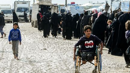 Des déplacés font la queue, le 28 mars 2019, dans le camp de Al-Hol, dans le nord-est de la Syrie, qui accueille notamment des membres de l'Etat islamique ayant fui l'offensive contre le groupe jihadiste. (GIUSEPPE CACACE / AFP)