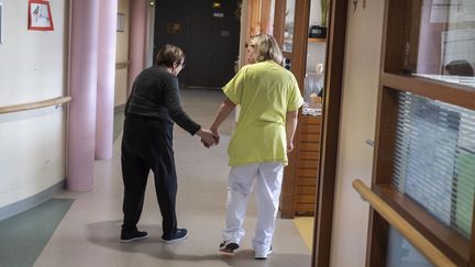 Une auxiliaire de vie et une résidente de l'Unité pour Personnes Âgées Désorientées, à Baugé en Anjou (Maine-et-Loire), le 28 mars 2022. (JEAN-MICHEL DELAGE / HANS LUCAS / AFP)