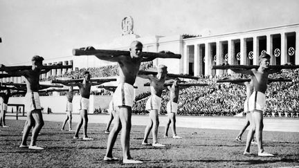 Des gymnastes allemands paradent dans un stade en 1938
 (STAFF / AFP)